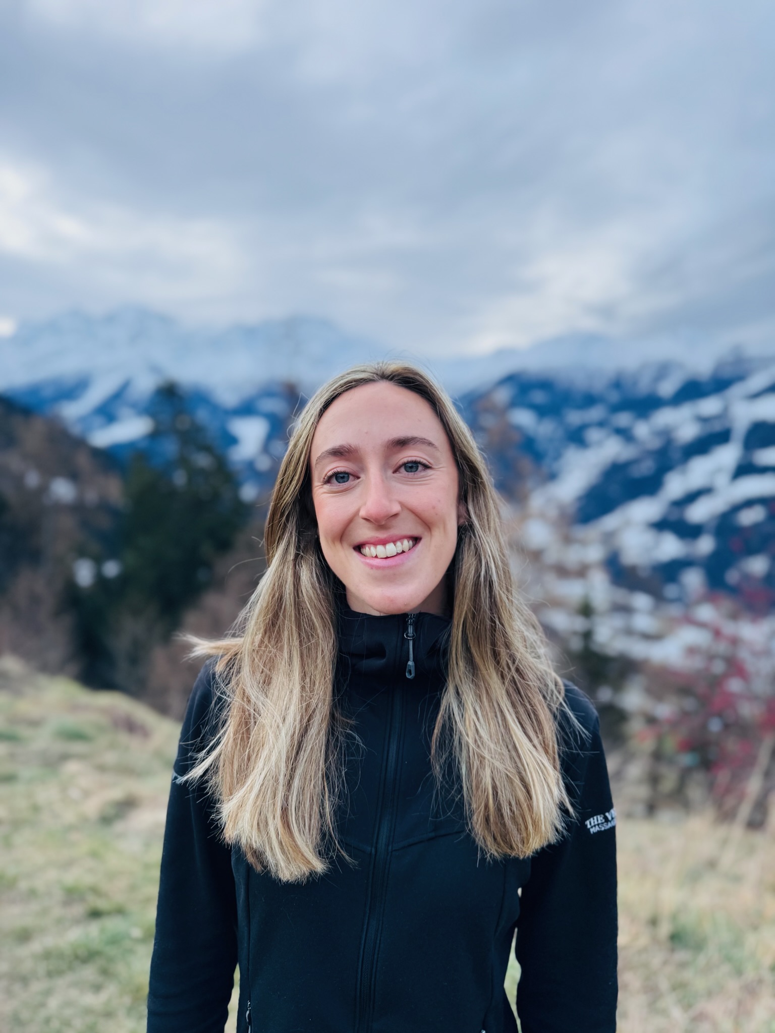 Ane Torres Madrazo, Senior Physiotherapist at The Verbier Touch, smiling with the snow-covered Verbier mountains behind her